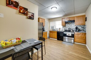 Una cocina compacta con armarios de madera, un refrigerador, estufa y microondas.