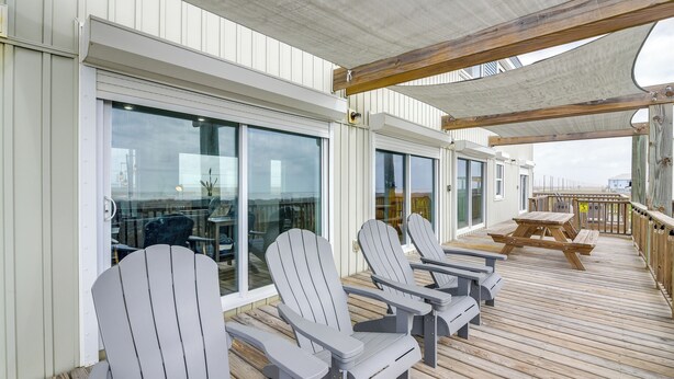 Une terrasse dotée de chaises Adirondack et d’une table en bois, offrant une vue panoramique.