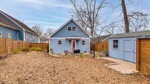 A residential backyard with a blue house, a wooden fence, and a shed. - 2 Mi to Duke & Dtwn Durham: Modern Home w/ Patio! (Durham)