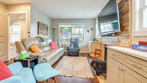 A living room with a sofa, chairs, a rug, a dog, and a TV. - 2 Mi to Duke & Dtwn Durham: Modern Home w/ Patio! (Durham)