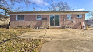 A single-story brick house with a front door, large windows, and a visible chimney. - Inkster Home Near Airport & Henry Ford Museum (Inkster)