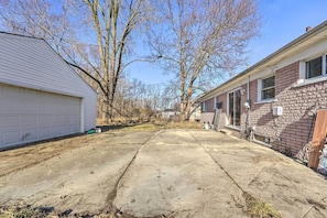 Uma entrada residencial com garagem e casa de tijolos.