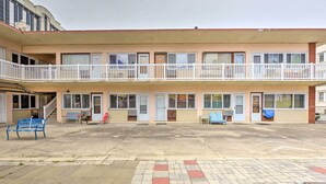 Un bâtiment à deux étages, doté d’un toit plat, de nombreuses fenêtres et d’un balcon avec des balustrades blanches.