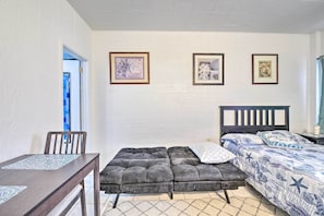 A bedroom with a bed, a chair, a table, and three framed pictures on the wall. - Atlantic City Studio w/ Beach Access On-site! (Atlantic City)