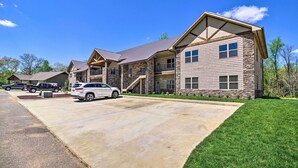 A modern two-story house with a stone facade, a covered front porch, and a driveway with parked cars. - Townsend Condo w/ Pool, Great Smoky Mountain Views (Townsend)