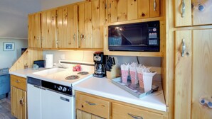 A kitchen with wooden cabinets, a microwave, a coffee maker, and a dishwasher. - Near Douglas Lake: Mountain Jewel Haven w/ Views (Sevierville)