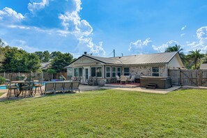A residential backyard with a swimming pool, outdoor seating, and a hot tub. - Welcoming Pensacola Home w/ Spacious Yard! (Pensacola)