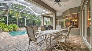 A covered patio with a pool, outdoor seating, and a view of the surrounding greenery. - Elegant Valrico Home ~ 15 Mi to Downtown Tampa! (Valrico)