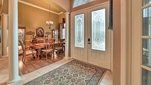 A formal dining room with a wooden table and chairs, a chandelier, and a patterned rug. - Elegant Valrico Home ~ 15 Mi to Downtown Tampa! (Valrico)
