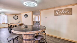 A cozy room with a wooden bar table, four stools, a clock, and a 'Relax' sign on the wall. - 'take 5' Retreat w/ Hot Tub: Relax, Rest, Refresh! (Somerset)