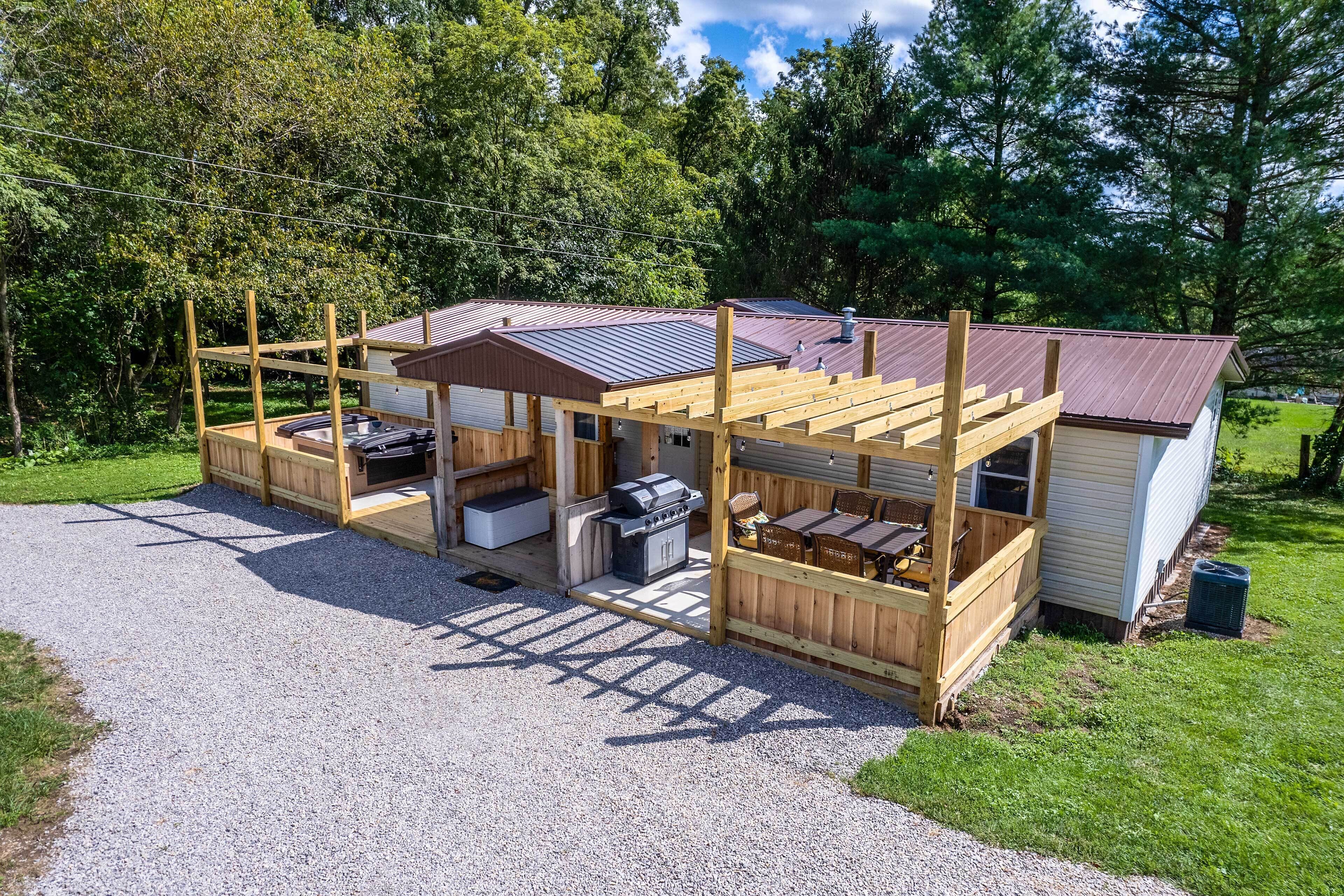 A wooden deck with a grill and outdoor seating area attached to a house.