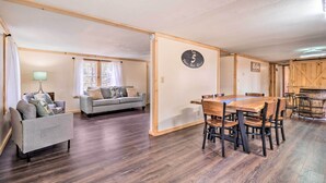A spacious living area with a dining table and chairs, a sofa, and a lamp. - 'take 5' Retreat w/ Hot Tub: Relax, Rest, Refresh! (Somerset)