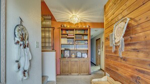 Una habitación con pared de madera, una estantería y un atrapasueños.