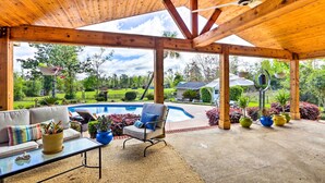 A covered patio area with a pool, outdoor furniture, and potted plants. - Sunny Florida Abode - Patio, Pool, & Fire Pit (Marianna)