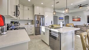 A modern kitchen with white cabinetry, stainless steel appliances, and a central island. - Stunning Laguna Vista Retreat w/ Pool & Grill (Port Isabel)