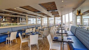 A restaurant with high ceilings, a bar area, and seating with a view. - Private Beach Access: Wildwood Crest Retreat (Wildwood Crest)