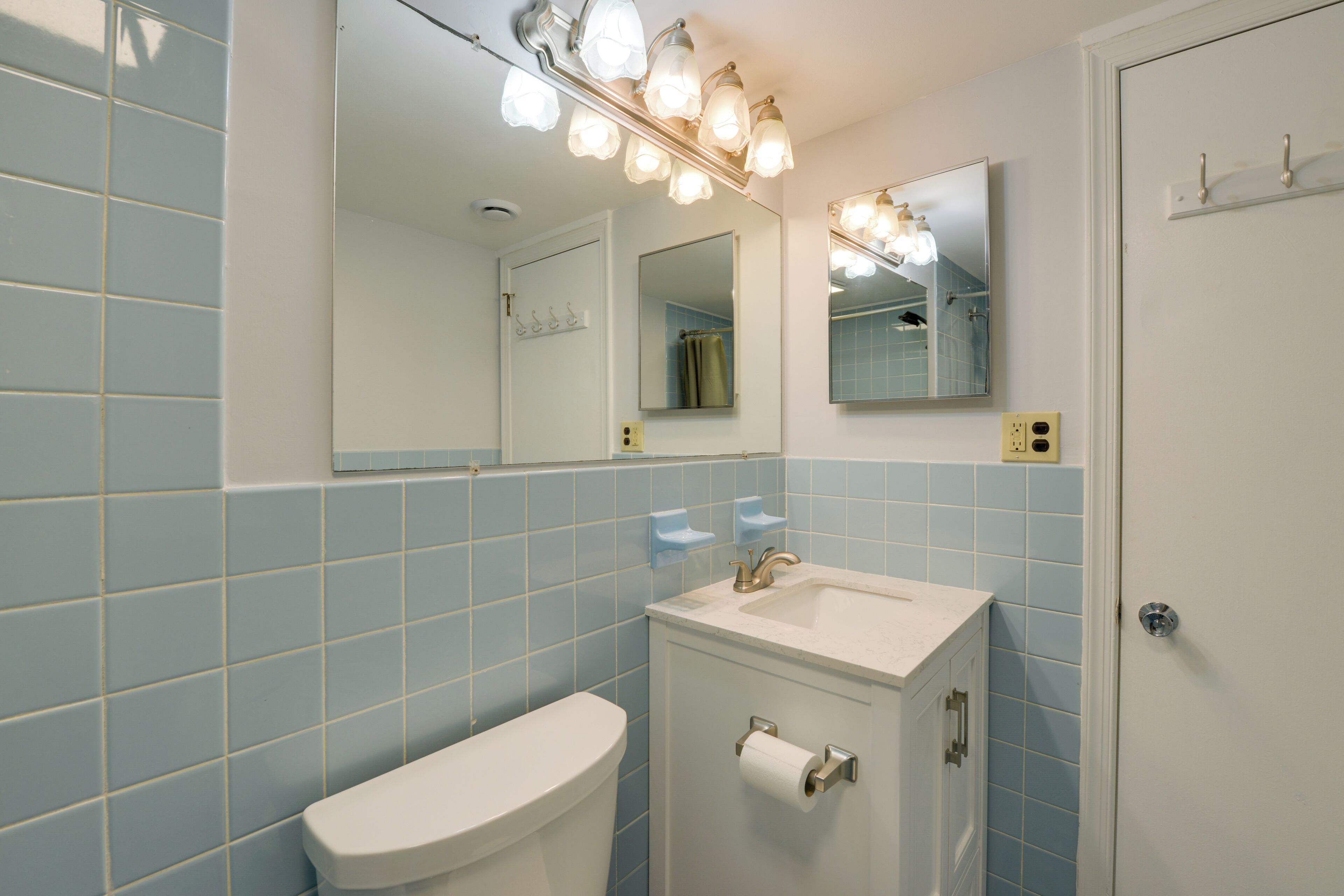 Ein Badezimmer mit Toilette, Waschbecken und Spiegeln.
