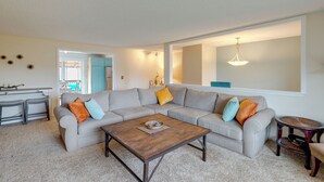 A living room with a sectional sofa, a coffee table, and a dining area with a bench. - Rockaway Beach Vacation Rental: Walk to Ocean (Rockaway Beach)