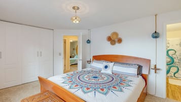 Quarto com cama de madeira, teto branco e porta que dá para outro espaço.