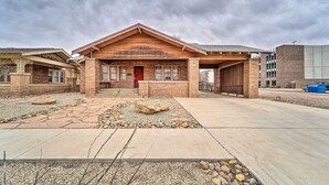 A building with a brick facade, a red door, and a stone-paved entrance area. - By Dtwn Lubbock! Spacious 4BR Home Near Texas Tech (Lubbock)