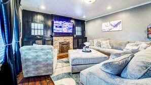 A living room with a fireplace, a television, and a couch. - By Dtwn Lubbock! Spacious 4BR Home Near Texas Tech (Lubbock)