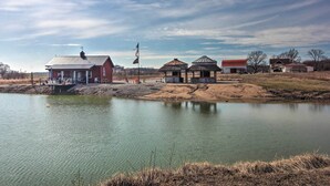 A lakeside property with a red building, a gazebo, and a barn. - Pheasant Game Farm Missouri Vacation Rental! (Braymer)