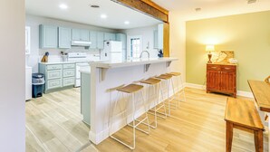 A modern kitchen with light blue cabinets, a white countertop, and a wooden bar stool area. - 5 Pools: Pet-friendly Palmetto Dunes Condo! (Hilton Head Island)
