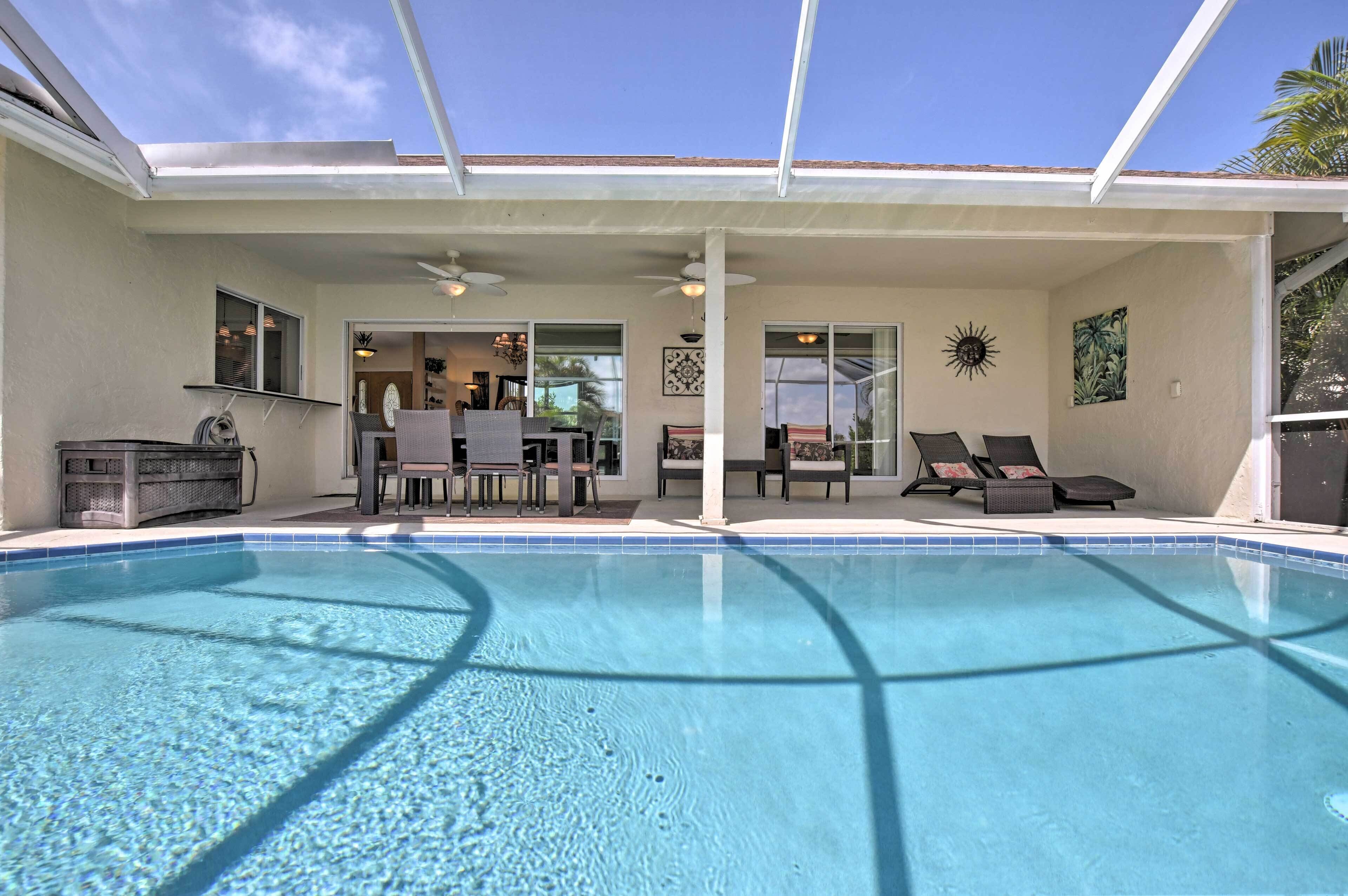 A clear blue pool with lounge chairs and a covered patio area.