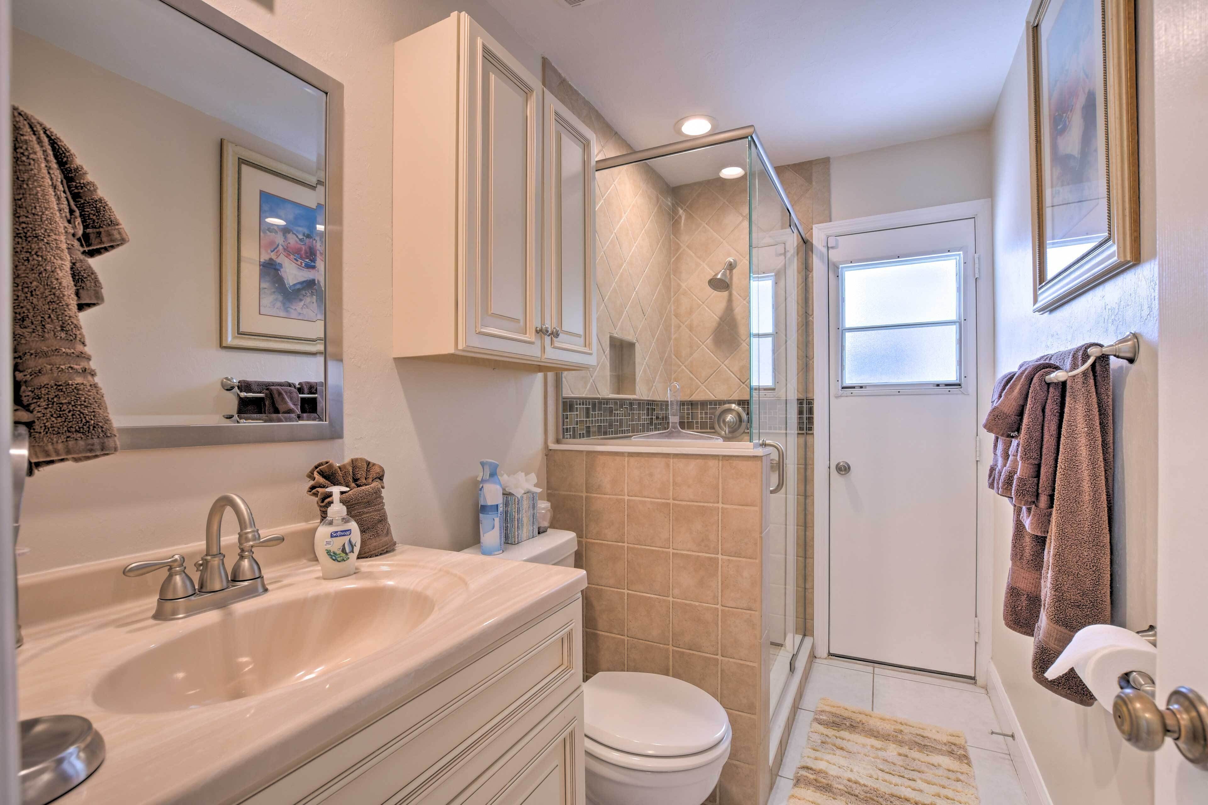A bathroom with a sink, toilet, and shower area.