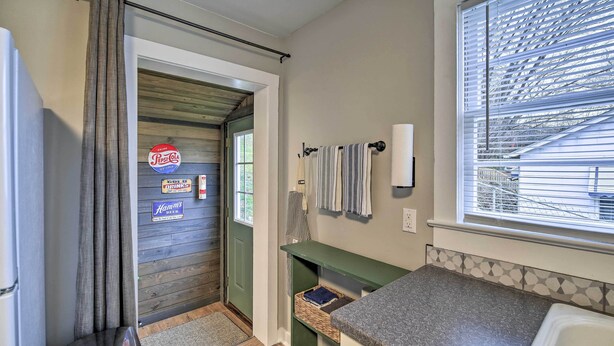 A compact kitchen with a sink, a window with blinds, a towel rack, and a door leading to another room. - Cozy Fries Escape w/ Mountain & River Views! (Fries)