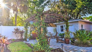 A patio area with a pergola, outdoor furniture, and potted plants. - Bright St Petersburg Home w/ Pergola & Garden (St. Petersburg)