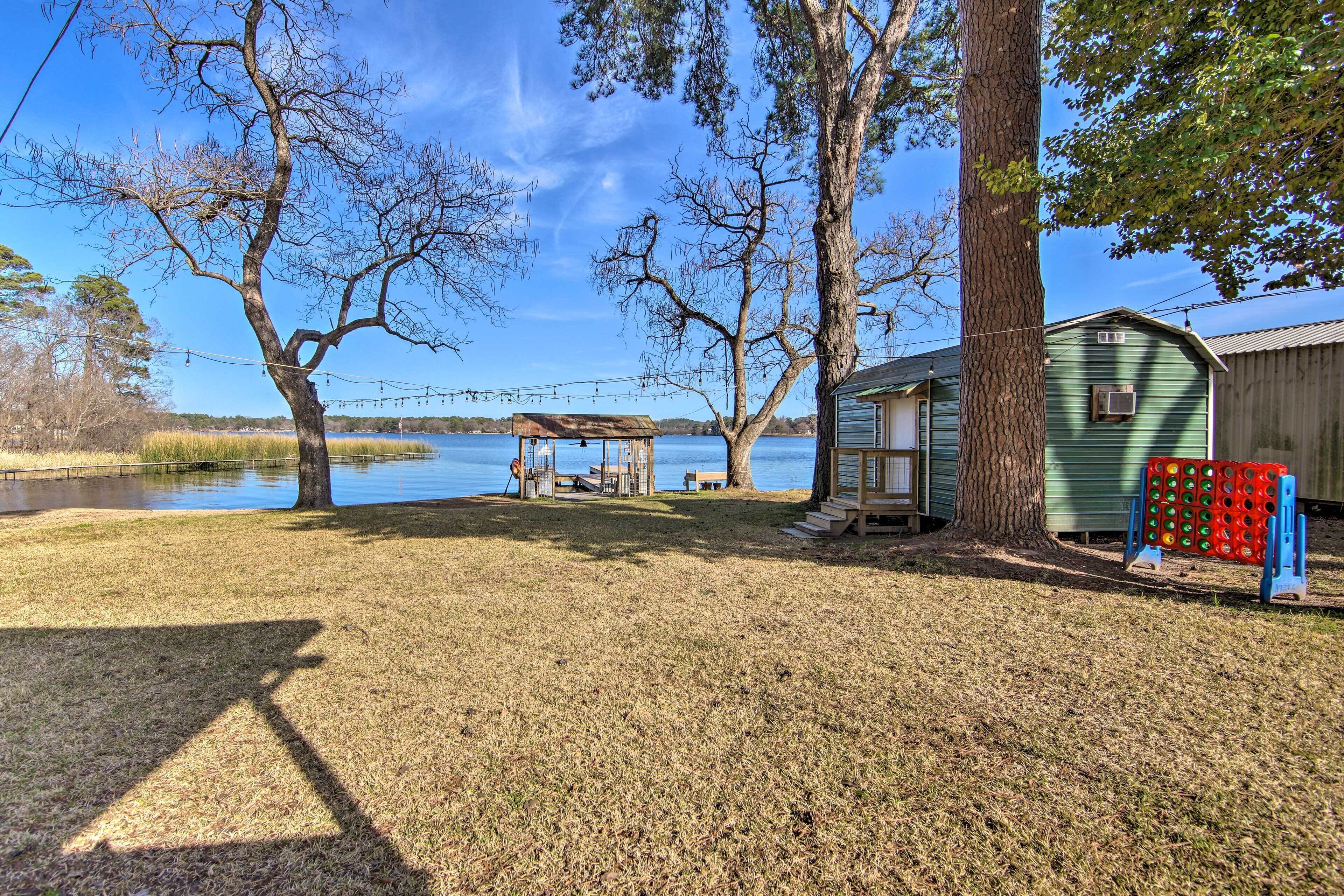A lakeside property with a gazebo, a small shed, and a wooden fence.