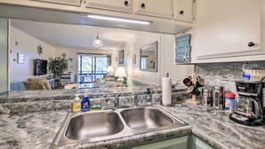 A kitchen with granite countertops, stainless steel sinks, and a coffee maker. - Walk to Ocean: Unit w/ Balconies in Myrtle Beach! (Myrtle Beach)