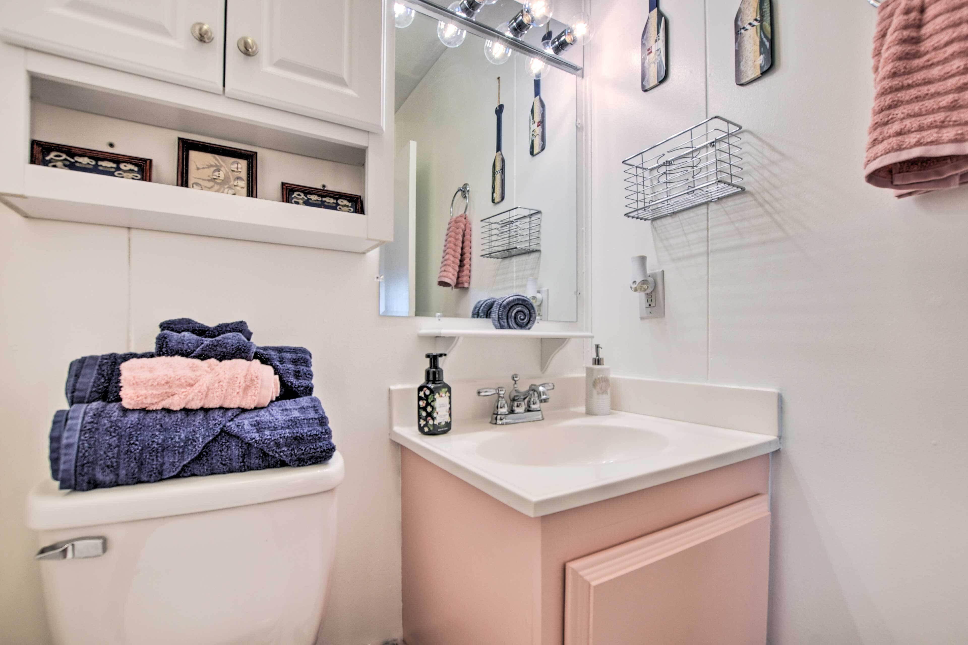 Ein Badezimmer mit Toilette, Waschbecken, Spiegel und Handtuchhalter.