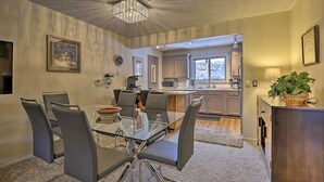 A modern kitchen with stainless steel appliances, a dining area with a glass table and chairs, and a view of the mountains through the window. - Condo on Fraser River < 4 Mi to Winter Park Resort (Winter Park)