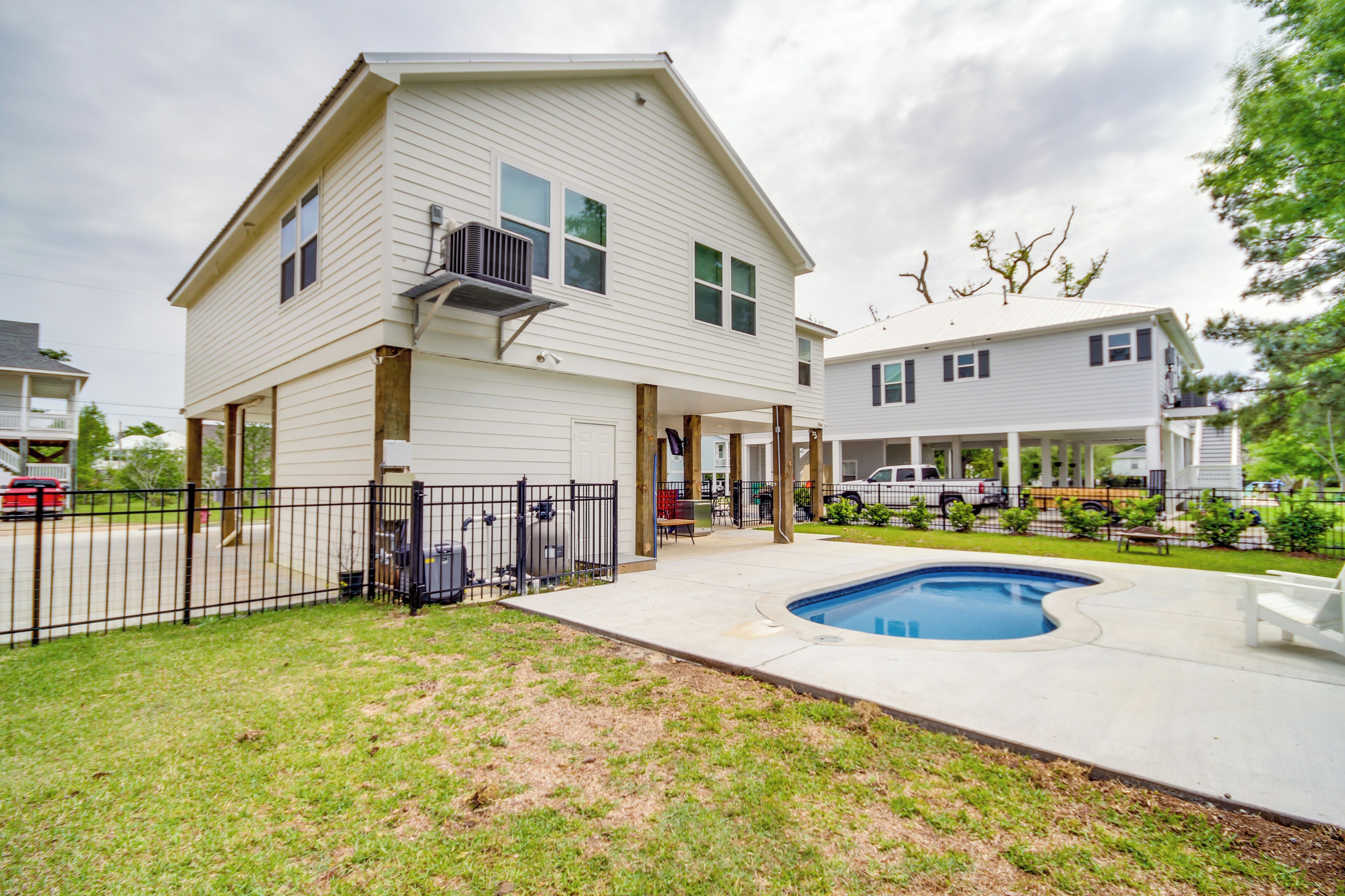 A two-story house with a covered patio and a swimming pool.