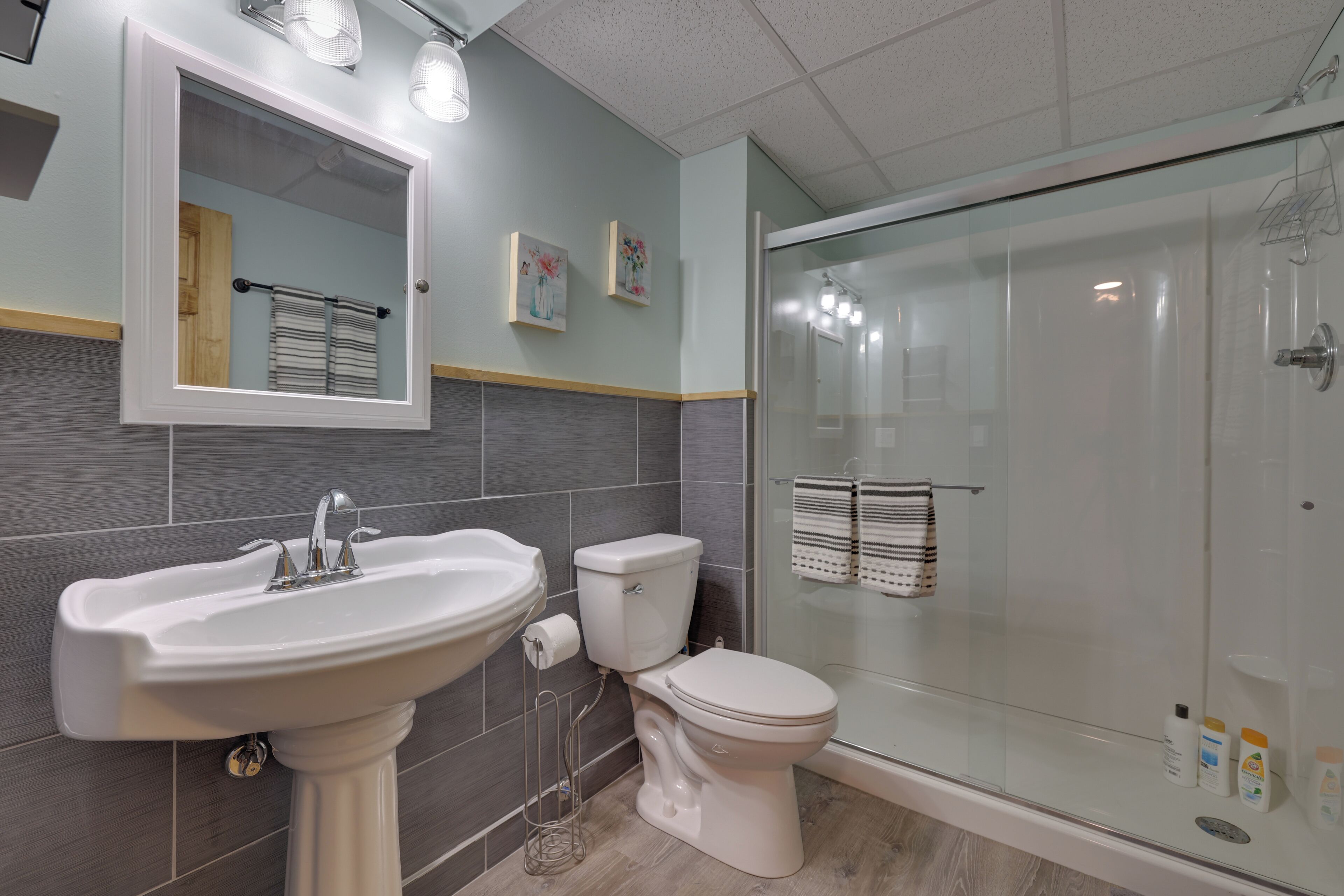 Ein modernes Badezimmer mit einem Standwaschbecken, Toilette und einer Duschkabine.