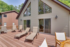 A deck with lounge chairs and a table, large sliding glass doors, and a building with a sloped roof. - Large Deck + Resort Amenities: Lake Ariel Retreat (Lake Ariel)