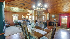 Un intérieur en bois avec une table à manger, des chaises et une cheminée.