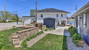 Ein Wohnhaus mit Garage, einem angelegten Vorgarten mit Steinmauer und einem kleinen Garten.