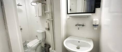 Un baño moderno con inodoro, lavamanos y ducha.