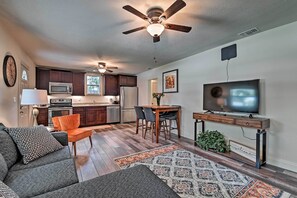 A modern kitchen with dark cabinets, a microwave, and a stainless steel refrigerator.