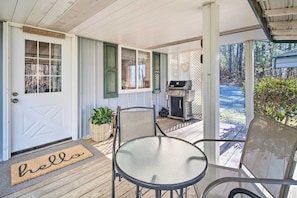 A covered porch with a grill, a welcome mat, and a table and chairs. - Penrose Home w/ Covered Deck + Fire Pit! (Penrose)