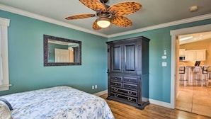 A bedroom with a bed, a dark wooden dresser, a ceiling fan, and a bathroom visible through an open door. - Lakefront Hot Springs Condo w/ Large Balcony! (Hot Springs)