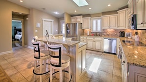 A spacious kitchen with a central island, stainless steel appliances, and a skylight. - Lakefront Hot Springs Condo w/ Large Balcony! (Hot Springs)
