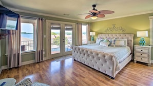 A bedroom with a large bed, a ceiling fan, and a view of the outdoors. - Lakefront Hot Springs Condo w/ Large Balcony! (Hot Springs)
