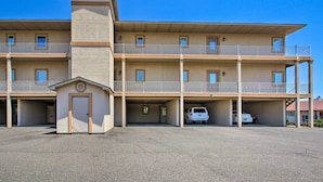 A multi-story building with a central tower, balconies, and parking spaces. - Lakefront Hot Springs Condo w/ Large Balcony! (Hot Springs)