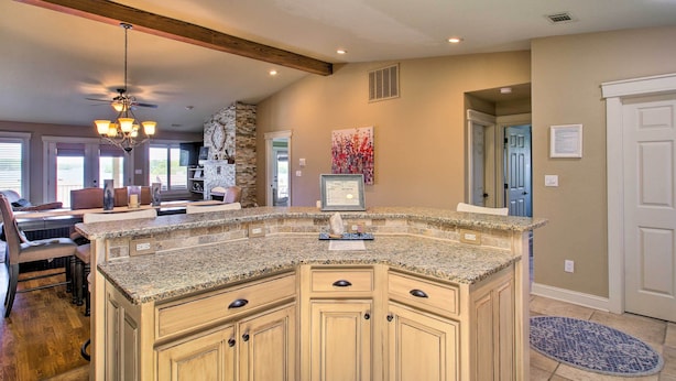 A kitchen with a large island, wooden cabinets, and a chandelier. - Lakefront Hot Springs Condo w/ Large Balcony! (Hot Springs)