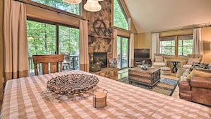 Una sala de estar amplia con chimenea, ventanas grandes y una zona de estar acogedora.