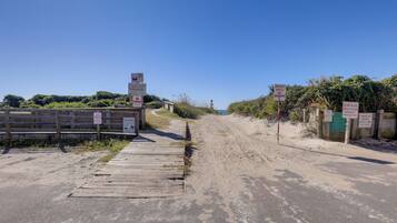 A beach access road with signs indicating no parking and beach access only.